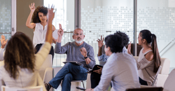 Mature male HOA president leads his neighbors in a vote during an HOA meeting
