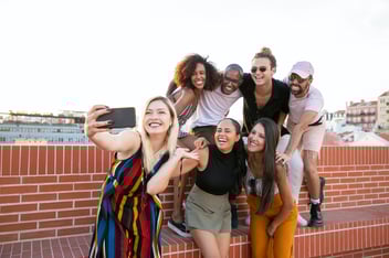 Diverse group of millennials posing for a selfie on a rooftop