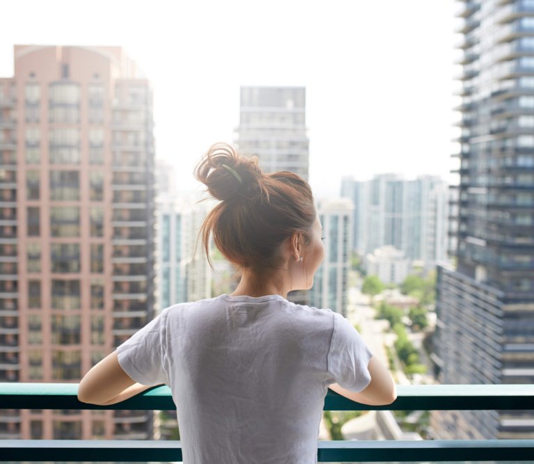 Woman looking out from apartment building